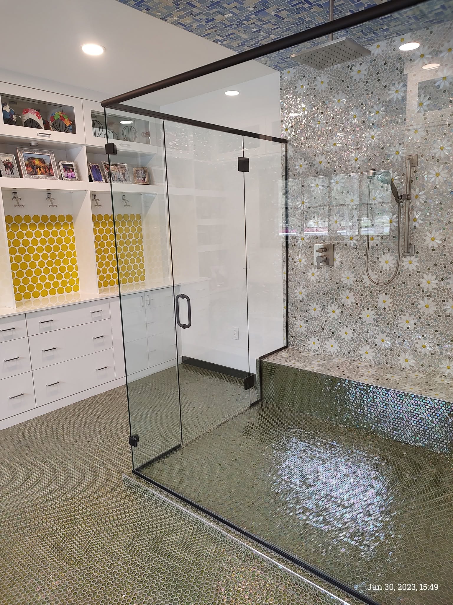 Light bathroom with a glass-enclosed mosaic tile shower